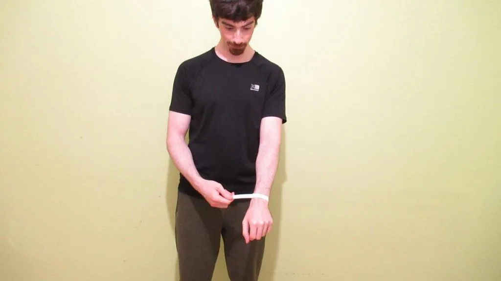 A man showing that he has a normal wrist circumference measurement for a male