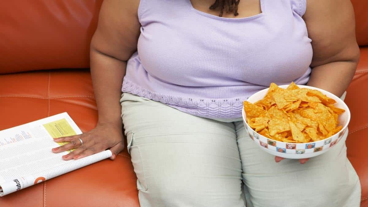 A woman with 80 inch hips eating food on the sofa