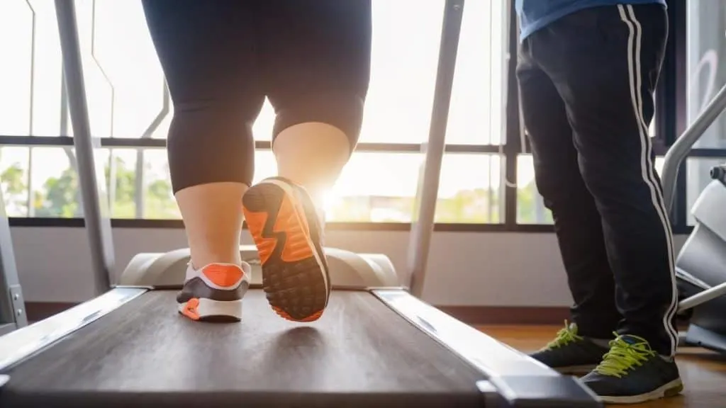 A woman with big 12.5 inch ankles running on a treadmill