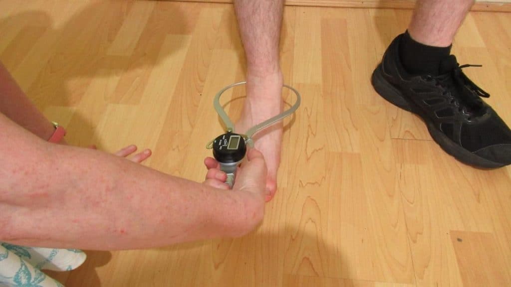 A person showing how to measure ankle width