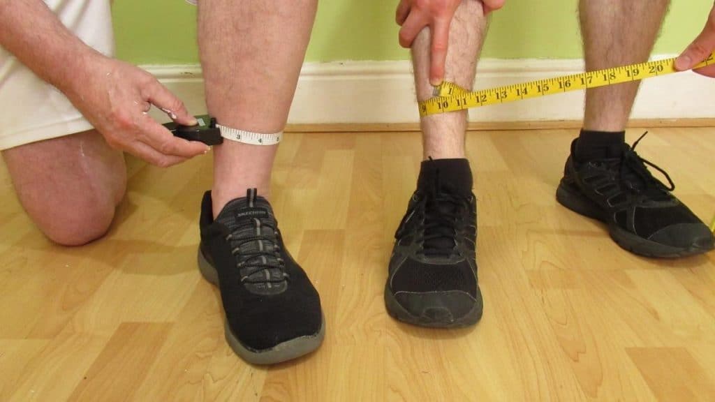 Two men measuring their ankles to see if they have the ideal ankle size