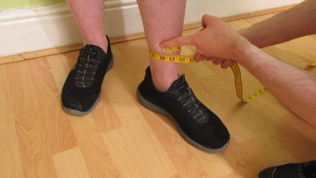 A man demonstrating where to measure your ankle