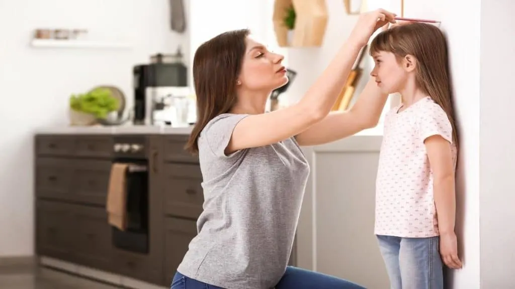 A girl getting measured to see if she has an average 10 year old height