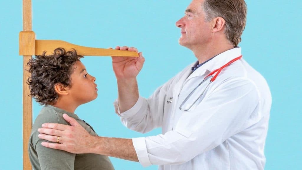 A boy getting his height measured to see if he has the average 12 year old height