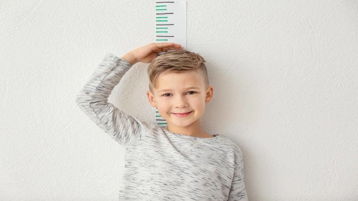 A boy getting measured to see if he is of an average height for 10 year olds