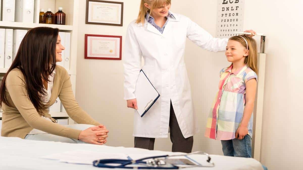 An eleven year old girl getting measured to see if she has an average height for 11 year olds