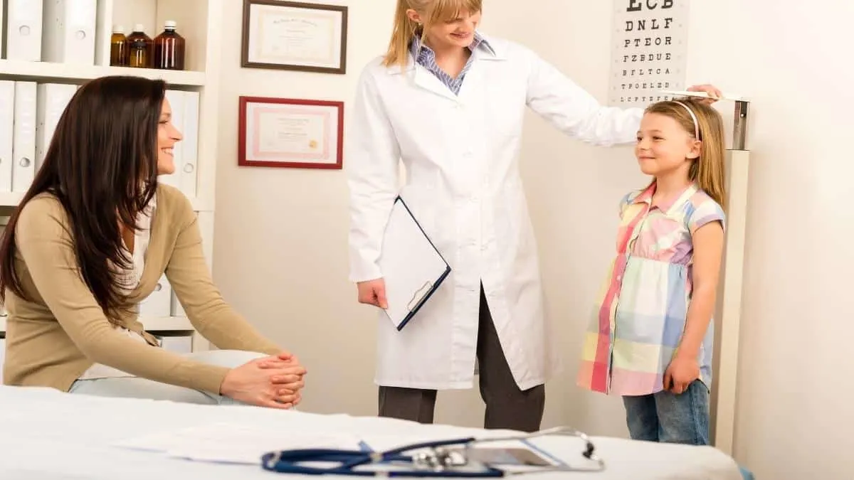 An eleven year old girl getting measured to see if she has an average height for 11 year olds