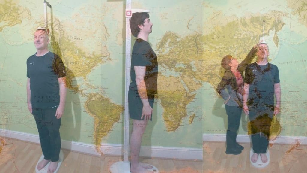 Some men demonstrating the average male height worldwide using a map of the world