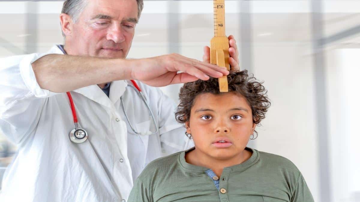 A boy being measured to see if he has an average 7th grader height