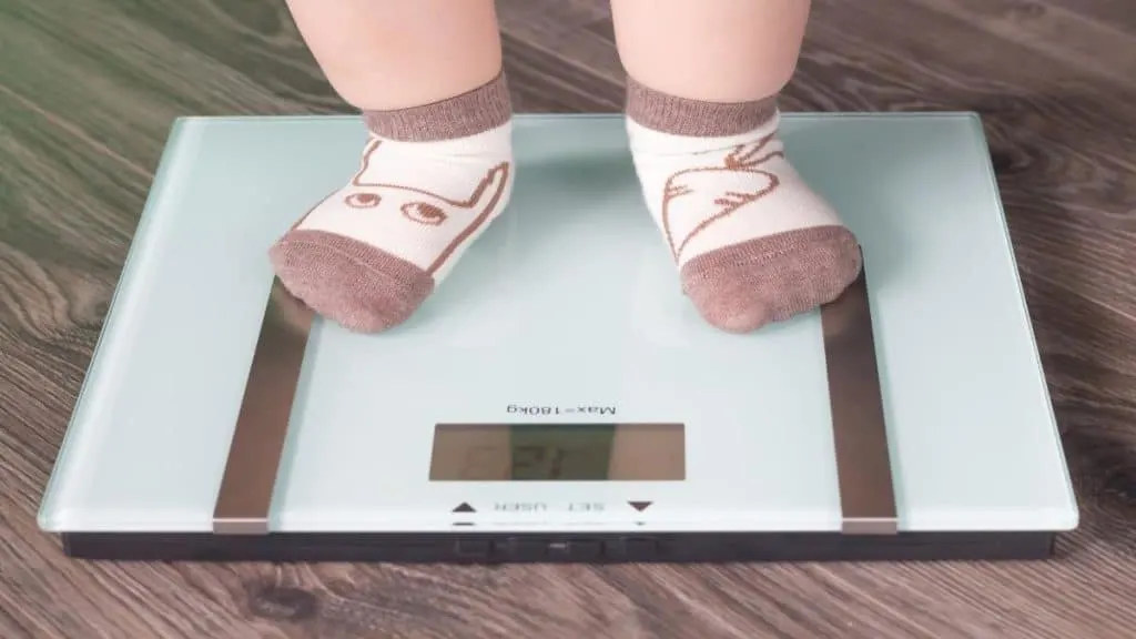 A child on a weighing scale who is of the average kindergartener weight