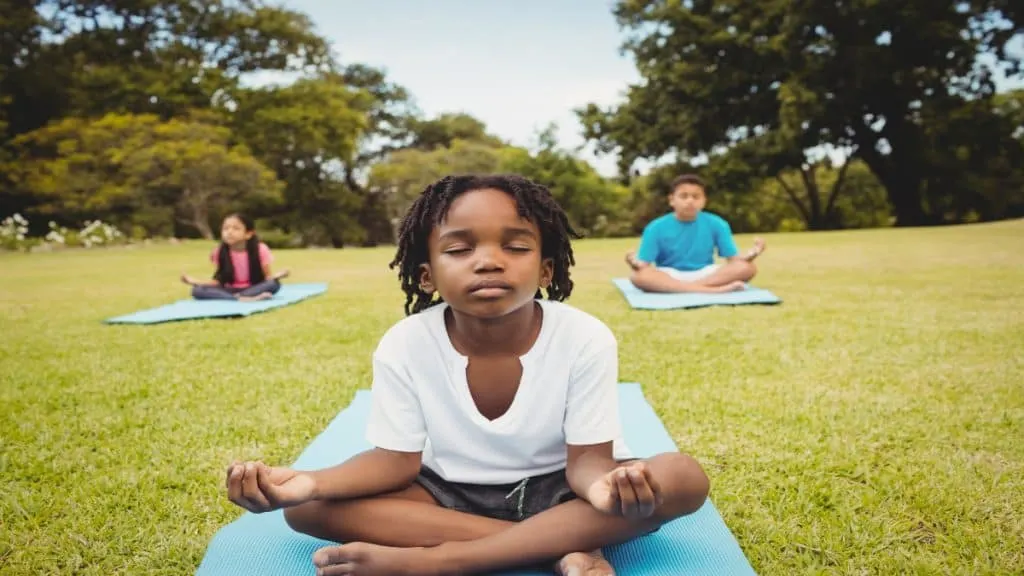 A boy doing yoga outside