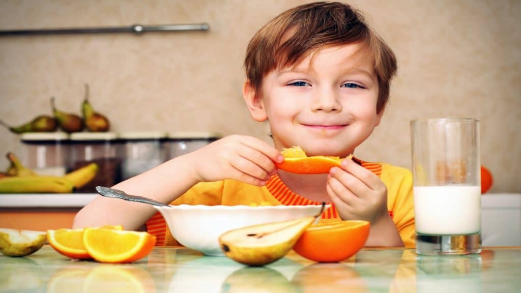 A boy eating an orange