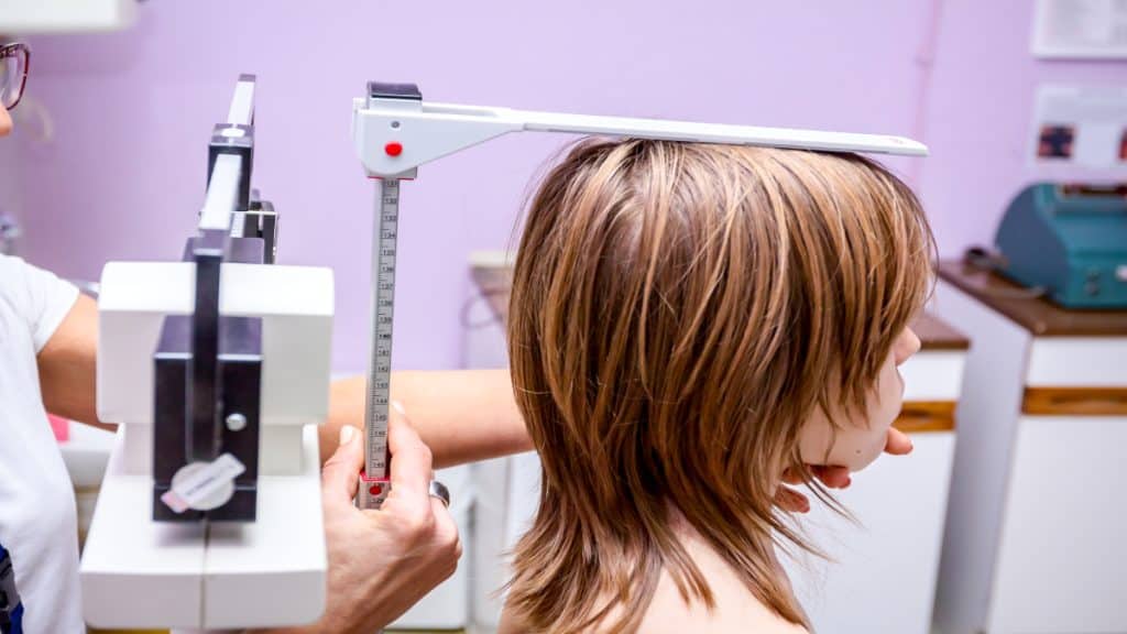 A girl getting her height measured with a stadiometer