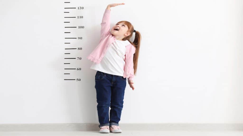 A girl trying to measure her height