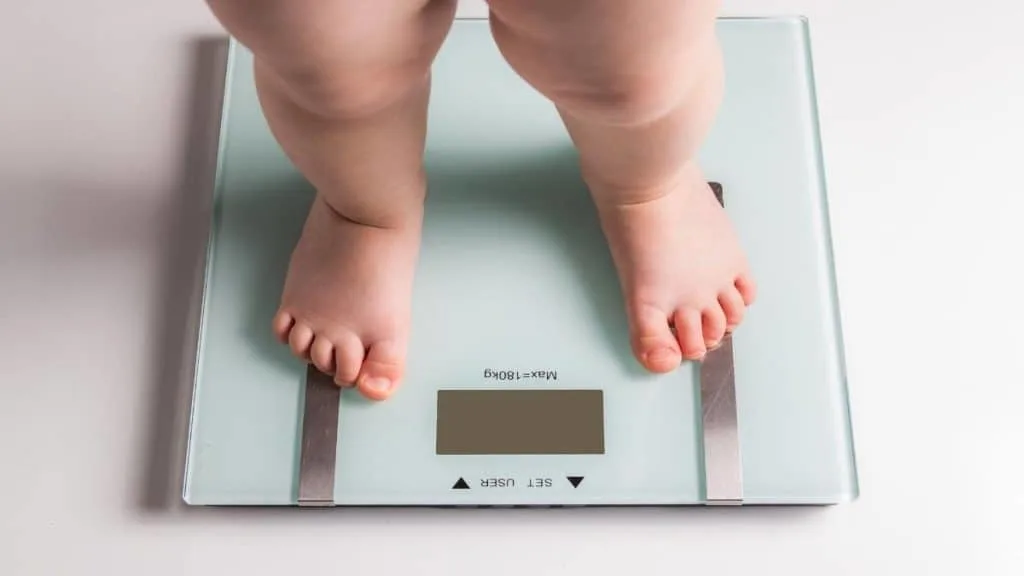 A person checking how much 1 year olds weigh