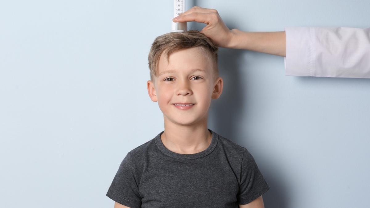 A 5th grader being measured to see how tall he is