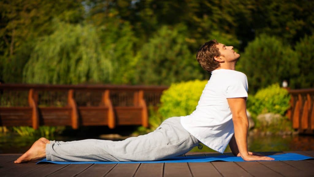 A man doing yoga outside