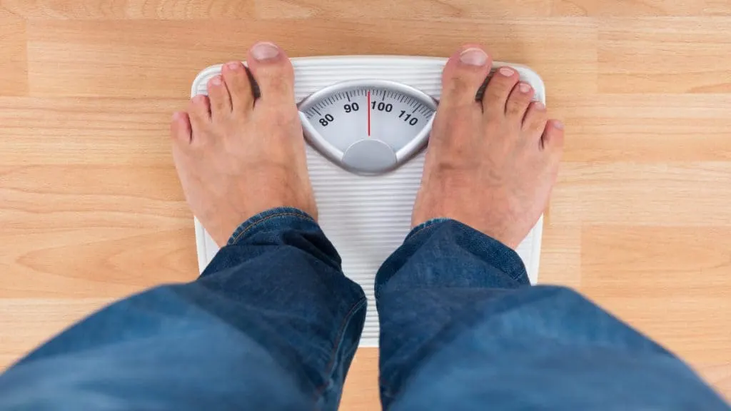 A man stood on a weighing scale