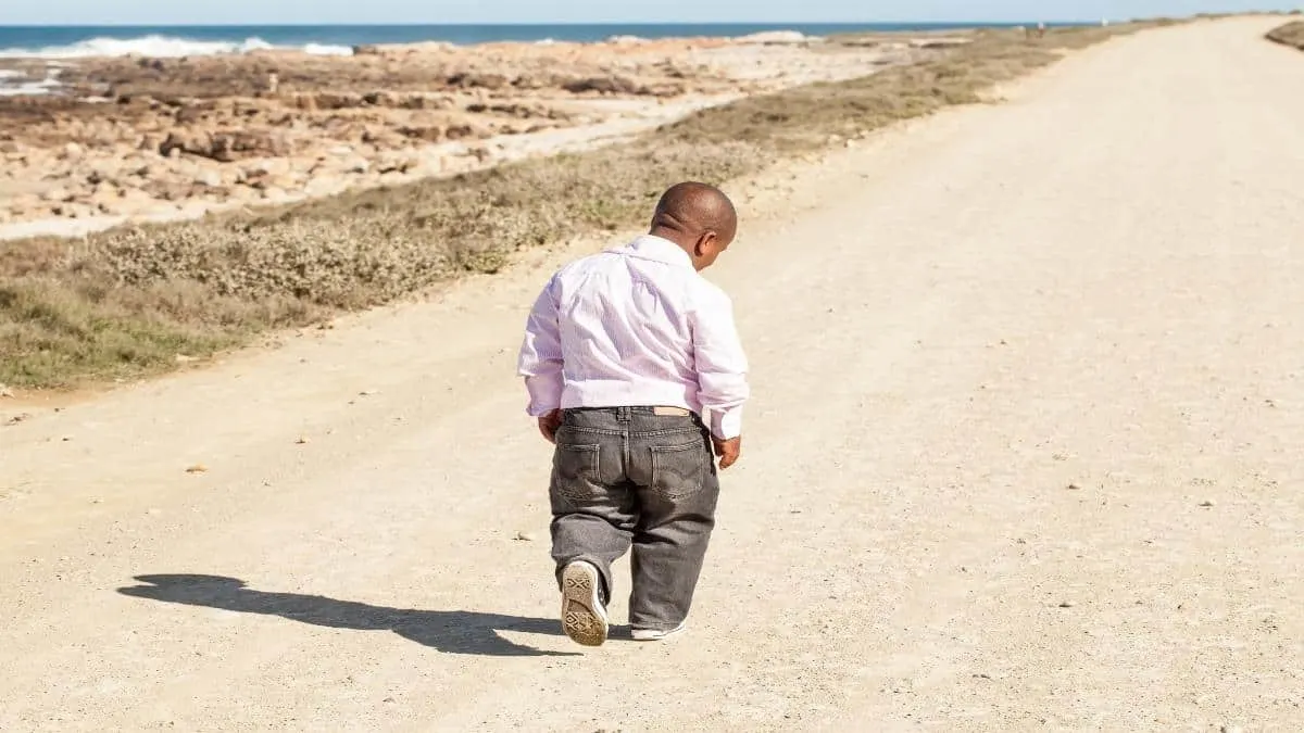 A 4-3 height man walking on the sand