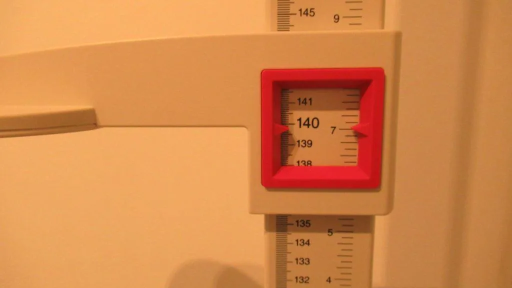 A stadiometer displaying the height 4 feet 7 inches