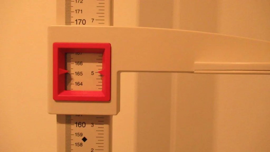 A stadiometer displaying the height 5 feet 5 inches