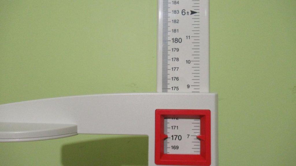 A stadiometer displaying the height 5 feet 7 inches