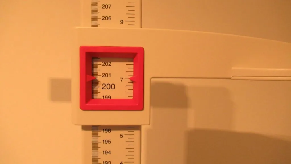 A stadiometer displaying the height 6 feet 7 inches