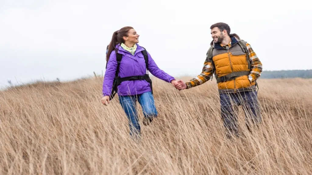 A couple holding hands while walking in nature