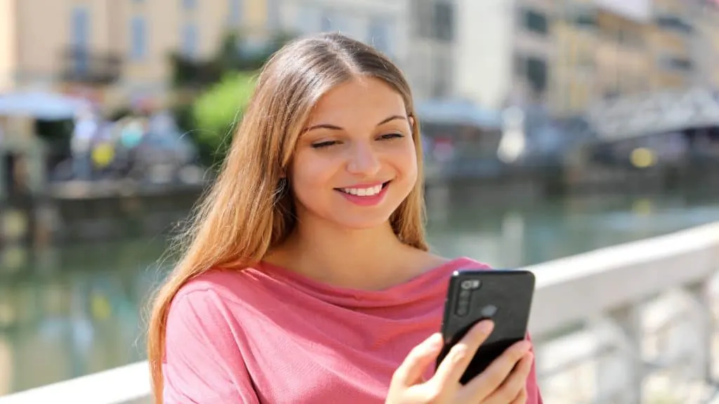 A happy woman scrolling on her phone