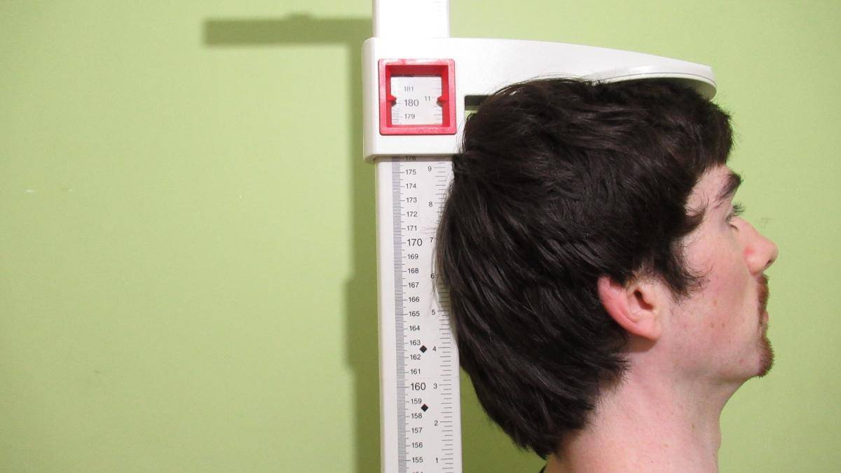 A 5'11 guy measuring his height to see how tall he is