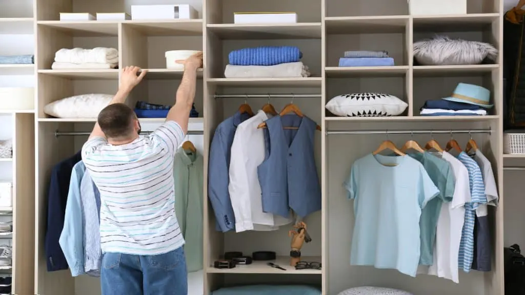 A man reaching for an object on a shelf