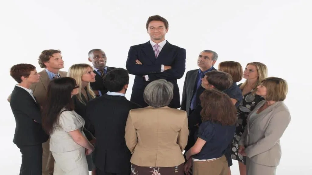 A tall man standing above his co-workers