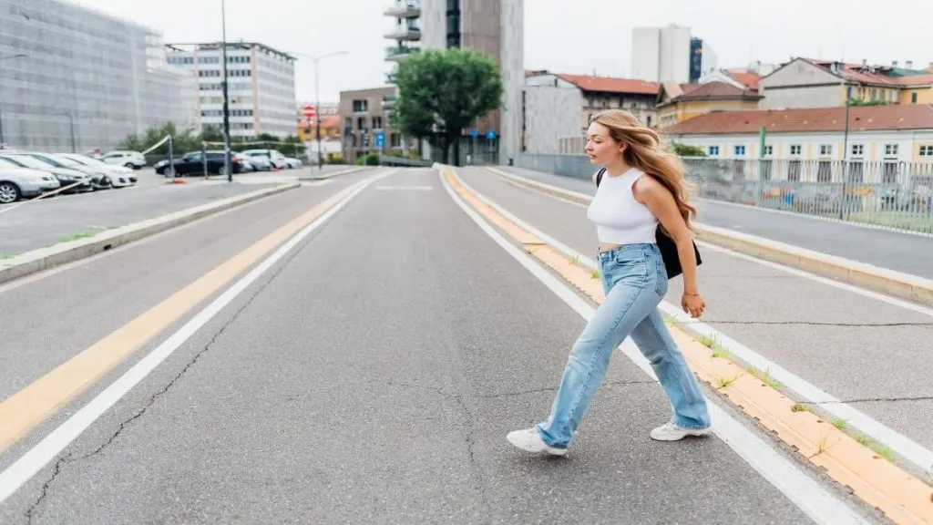 A young woman crossing the road