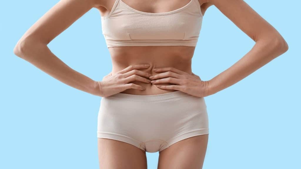 A BMI 11 woman holding her waist