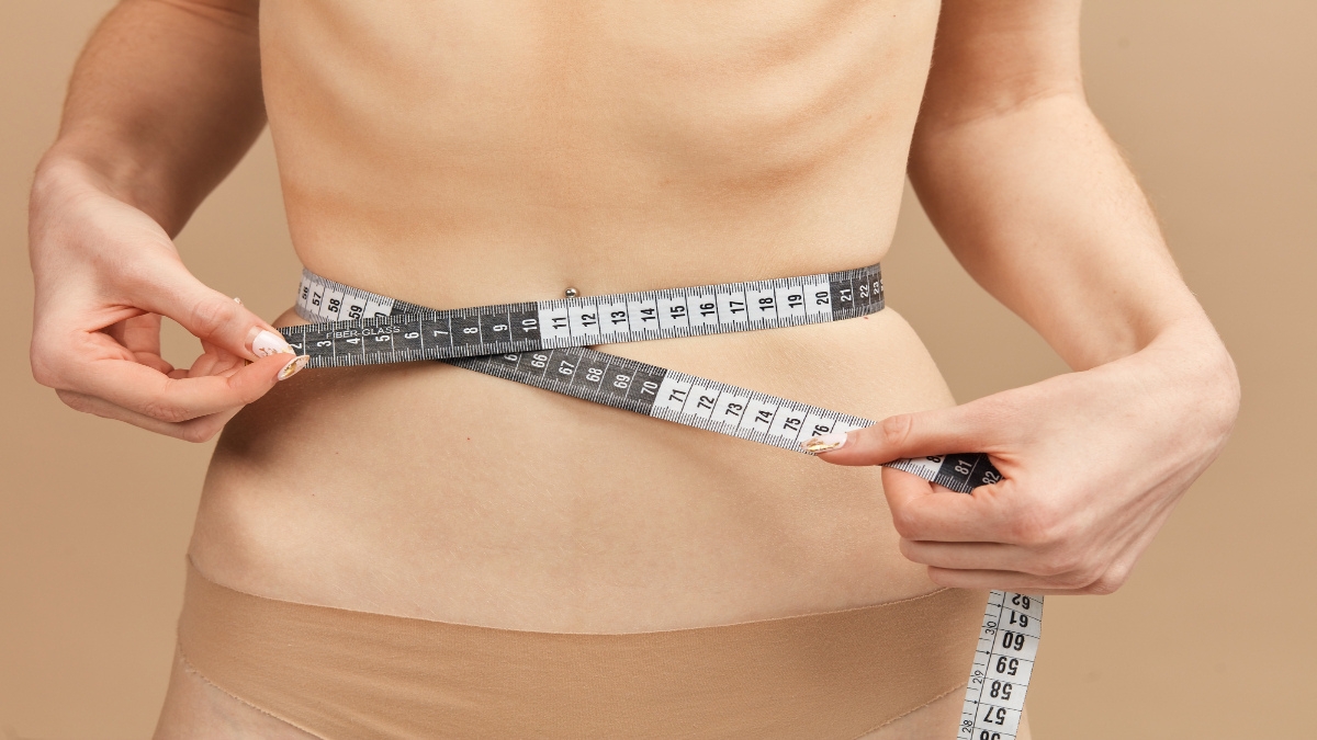 A BMI 15 woman measuring her waist