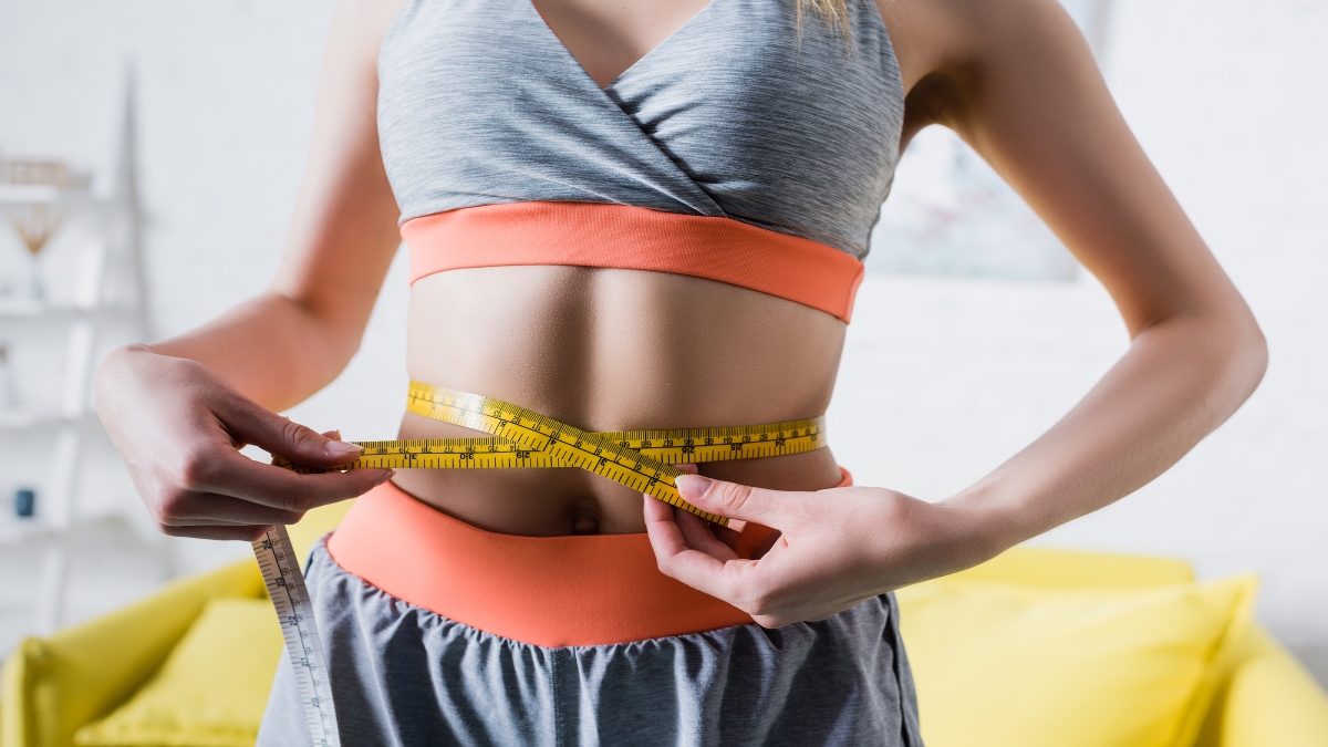 A BMI 18 woman measuring her waist