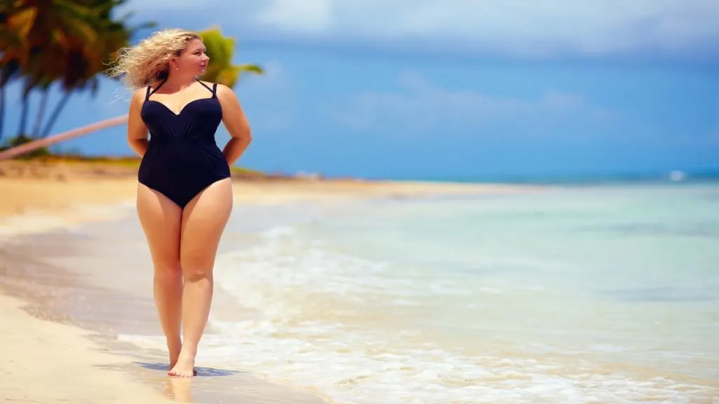 A picture of a BMI 25 female walking on the sand