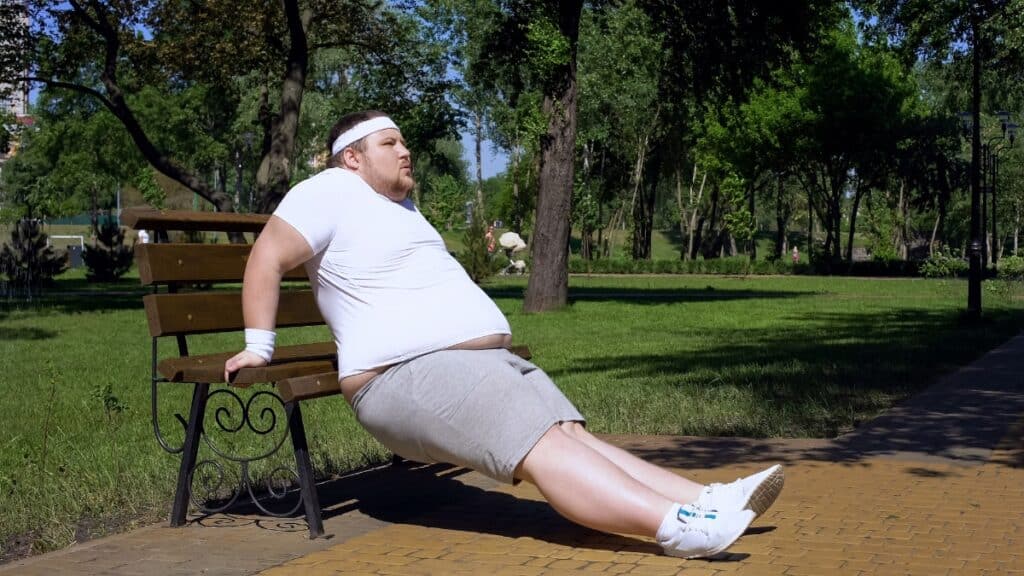 A BMI 48 man doing a workout at the park