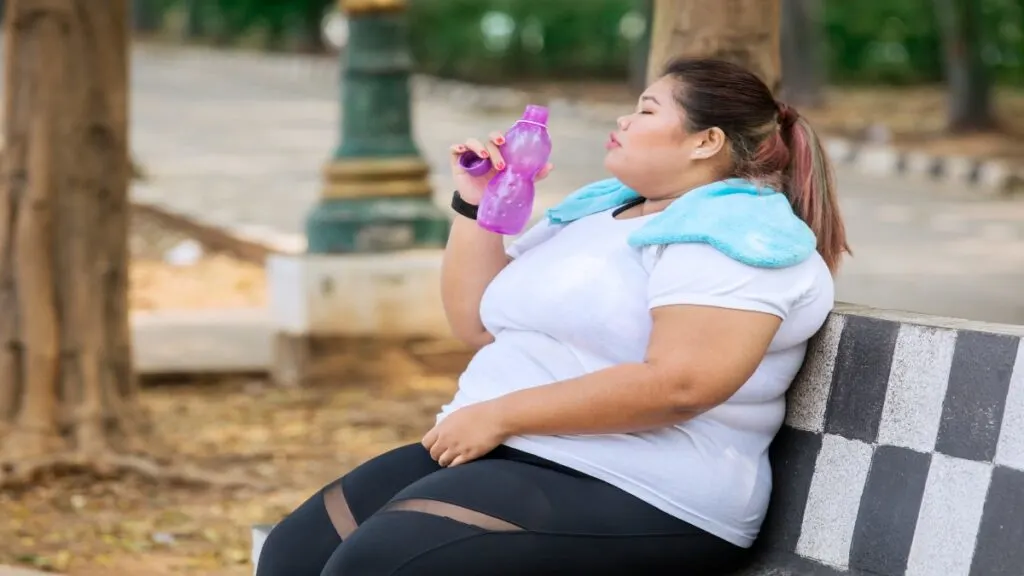 A BMI 48 woman drinking some water