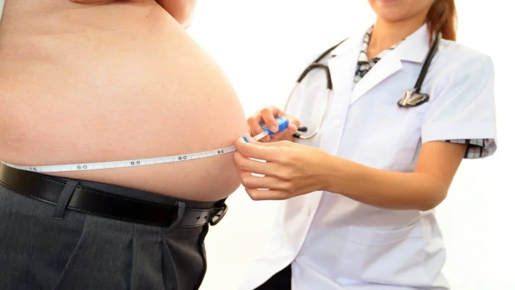 A man with a BMI of 42 getting his stomach measured