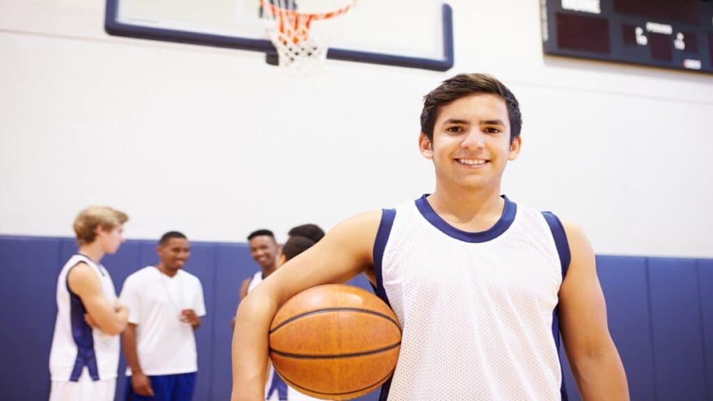 A 5 11 basketball player smiling on the court