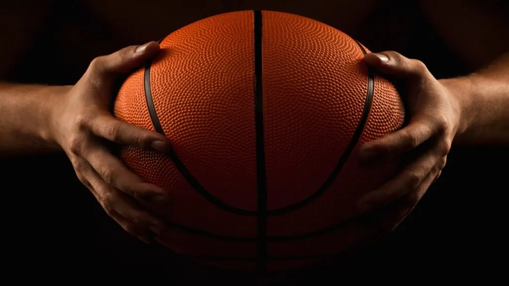 A 5 foot 10 basketball player holding a ball