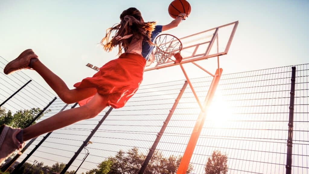 A 6’8 female basketball player dunking the ball