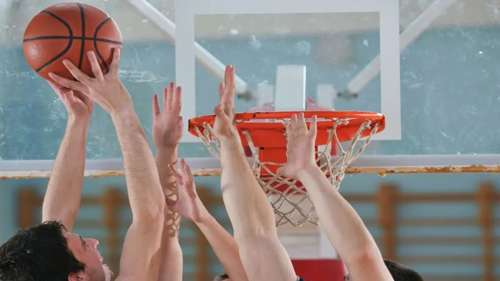 A 6 foot 7 basketball player throwing the ball in the hoop