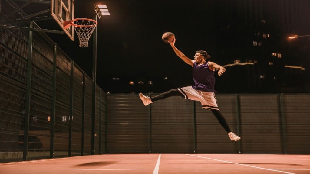 A 7’2 basketball player throwing the ball into the hoop