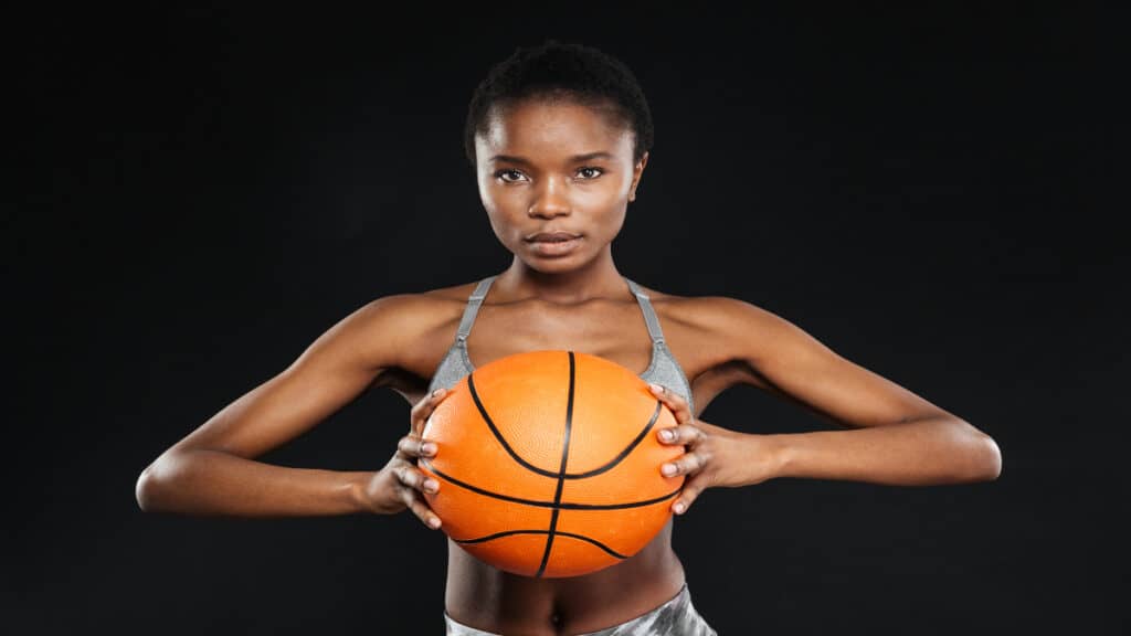 A woman holding a basketball who has an average height for a WNBA player