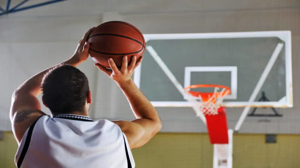 A man who has an average shooting guard height throwing the basketball