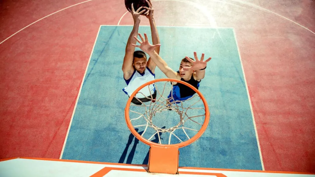 A man with a fairly average small forward height dunking the basketball