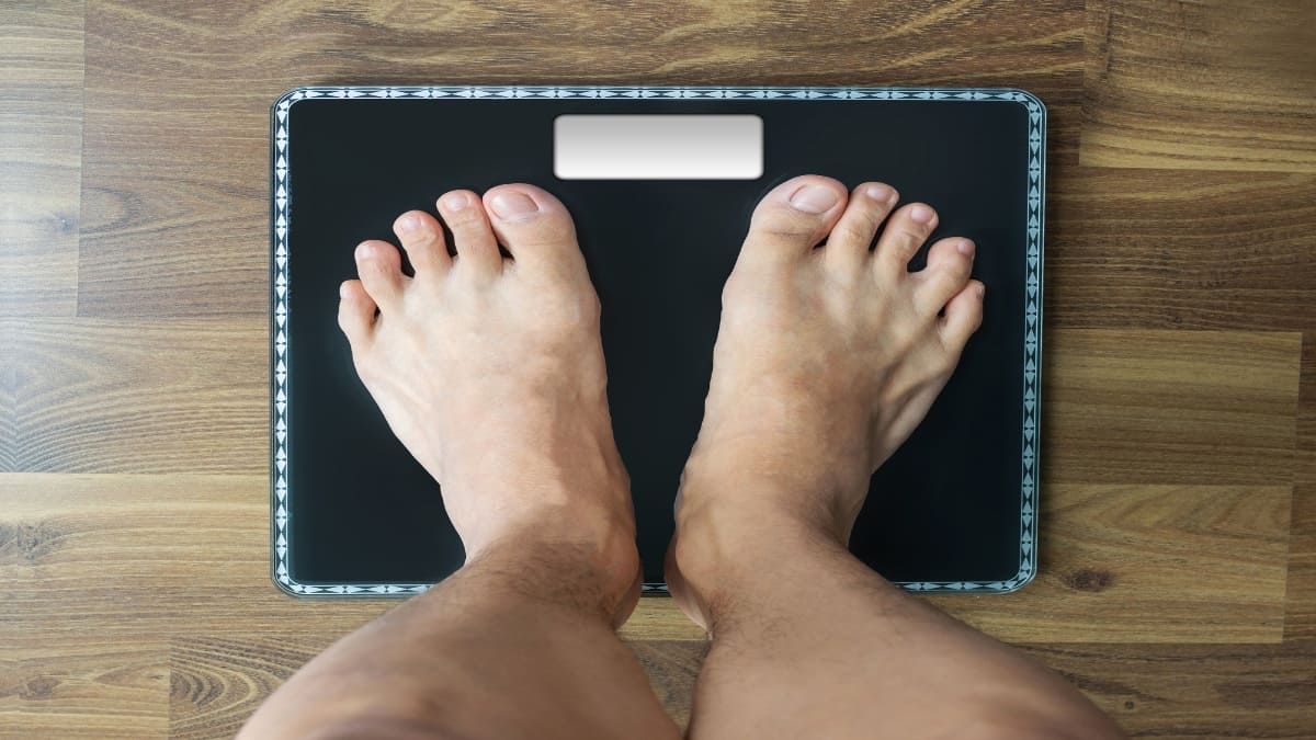 A man checking if he has an average weight for a 6'0 male