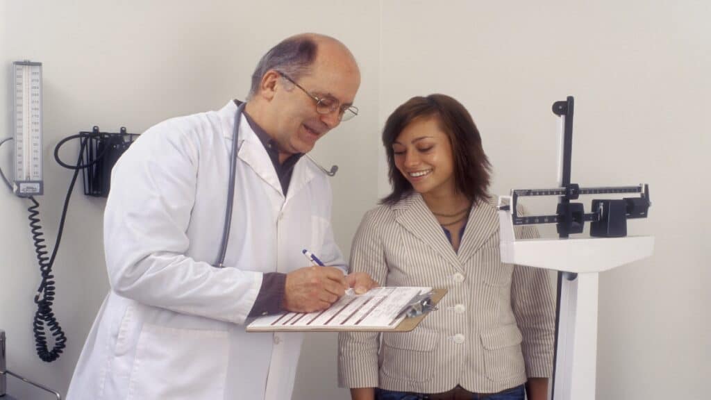 A doctor showing a woman that she has a healthy weight for a 5'1 female